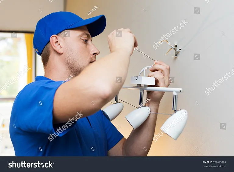 electrician at work - installing lamp on the wall